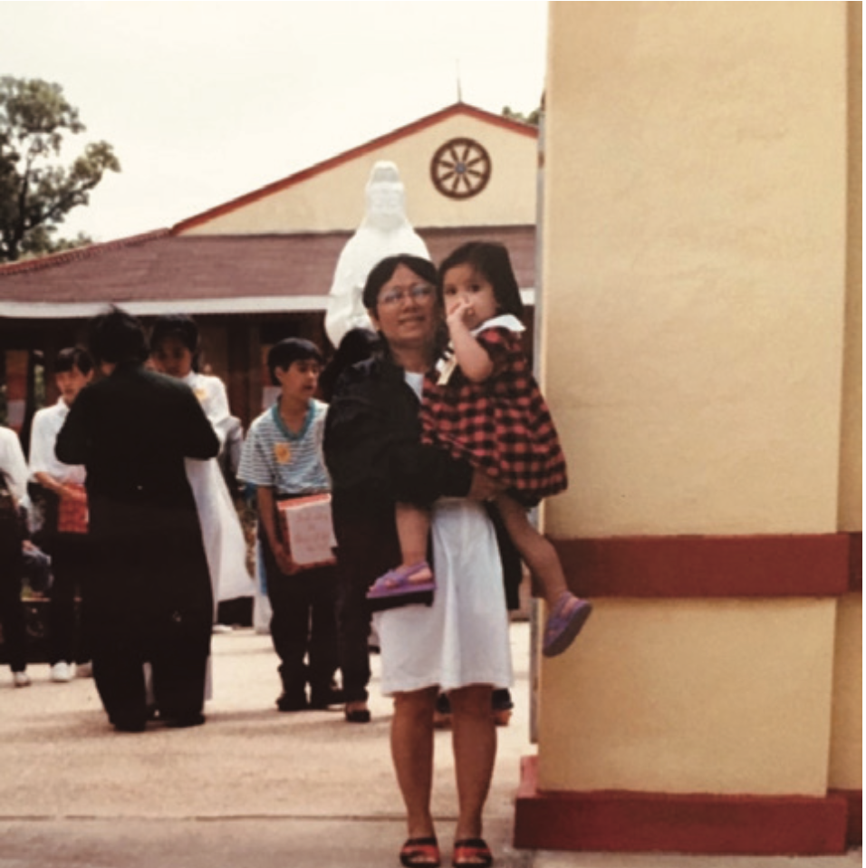 Nam, the founder's grandmother, holding a child outside a temple